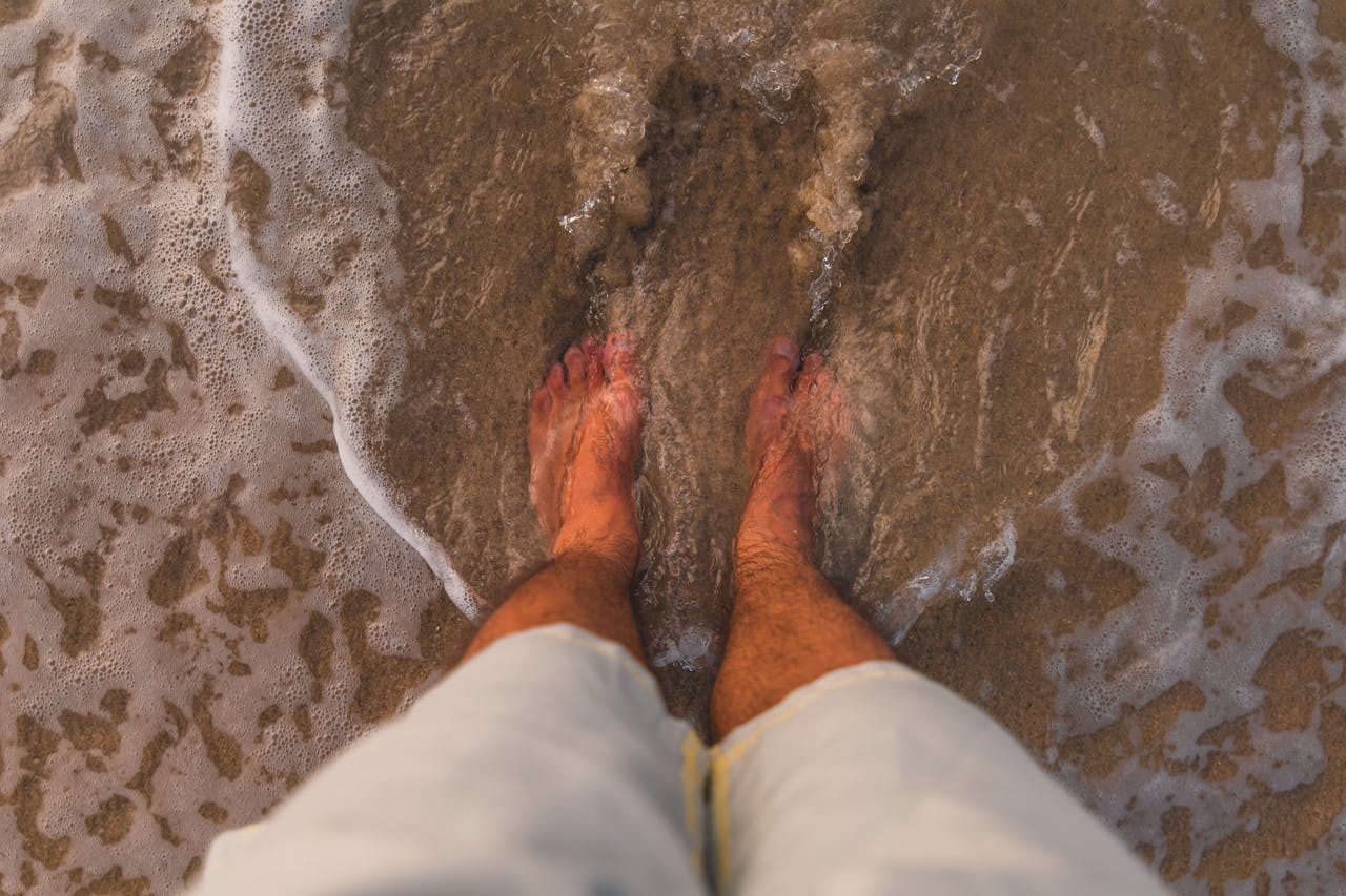 A relaxing view of feet in the sand along the seashore at Angra dos Reis, Brazil.